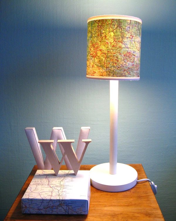 The finished map lamp on a bedside table beside cut-out letters
