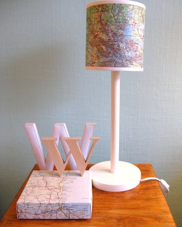The lamp unlit on the table, map shade and white base