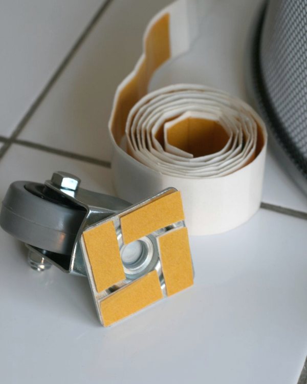 A castor and an adhesive cushion pad on the base of the bin
